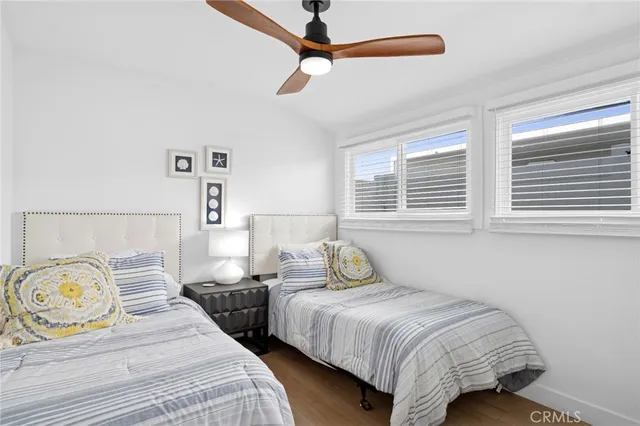 a bedroom with two beds and painting on the wall