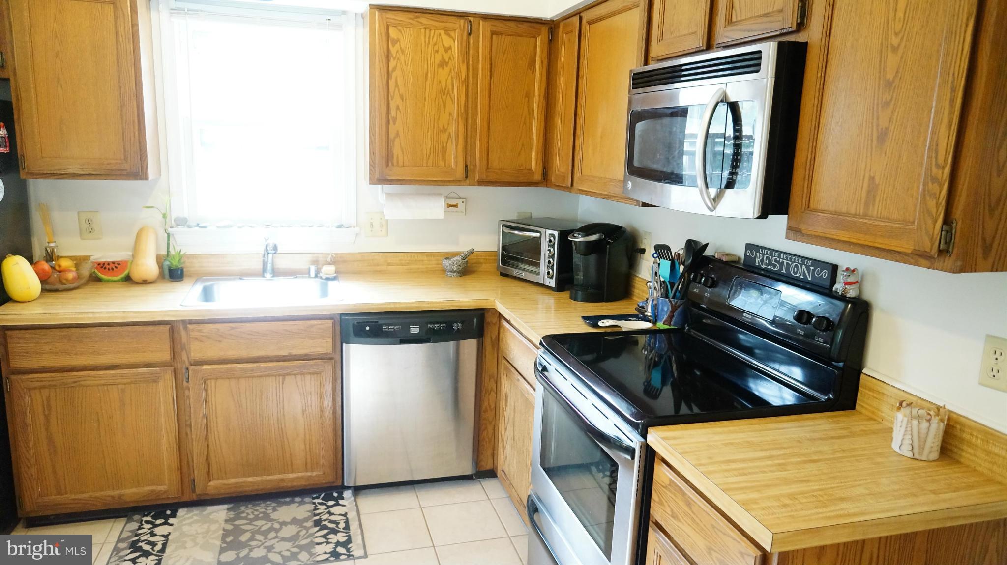 2117 Salt Kettle Way Reston, VA 20191 - Photo 11 of 30 a kitchen with stainless steel appliances granite countertop a sink stove and refrigerator