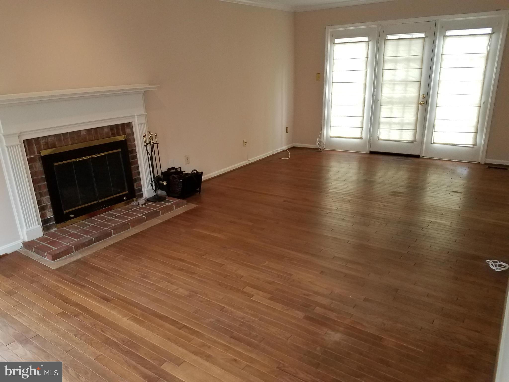 2117 Salt Kettle Way Reston, VA 20191 - Photo 5 of 30 an empty room with wooden floor fireplace and windows