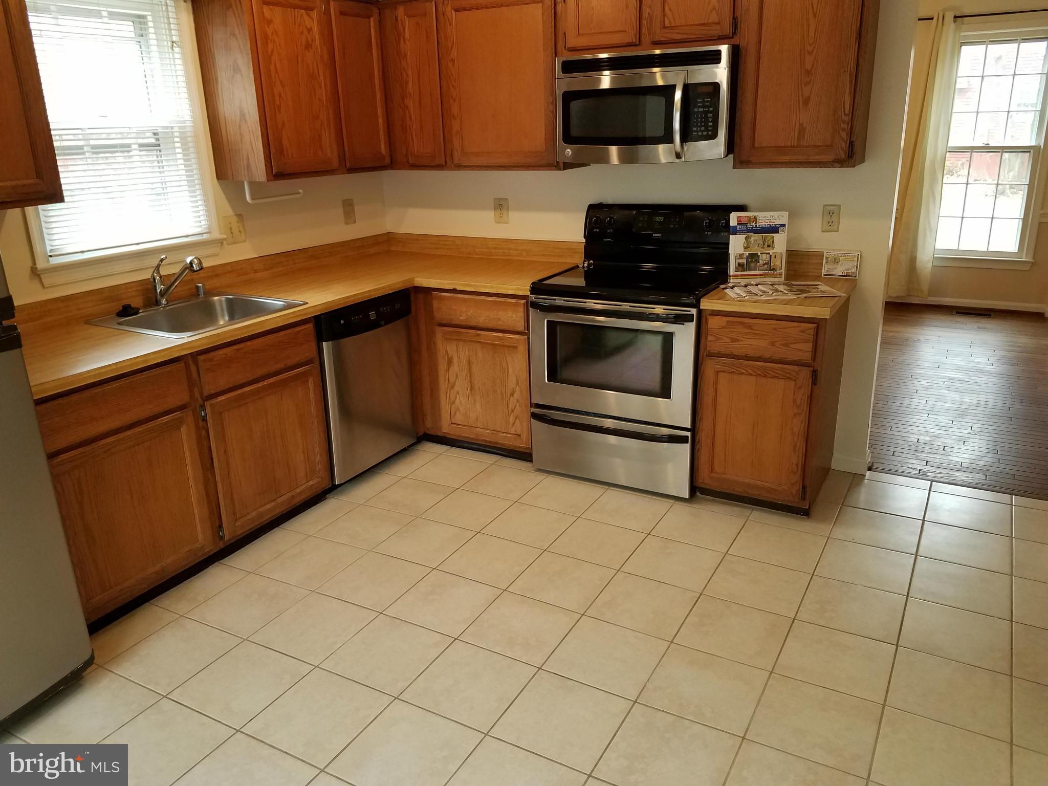 2117 Salt Kettle Way Reston, VA 20191 - Photo 8 of 30 a kitchen with granite countertop a stove top oven microwave and cabinets