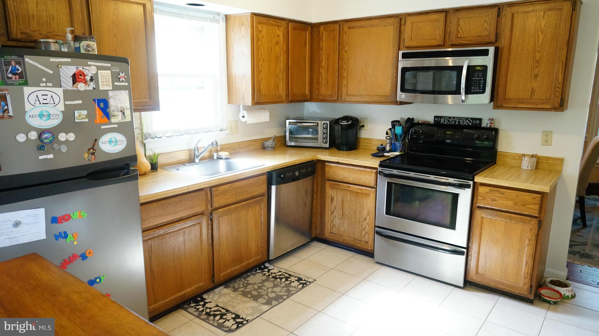 2117 Salt Kettle Way Reston, VA 20191 - Photo 9 of 30 a kitchen with stainless steel appliances granite countertop a stove a sink and a microwave
