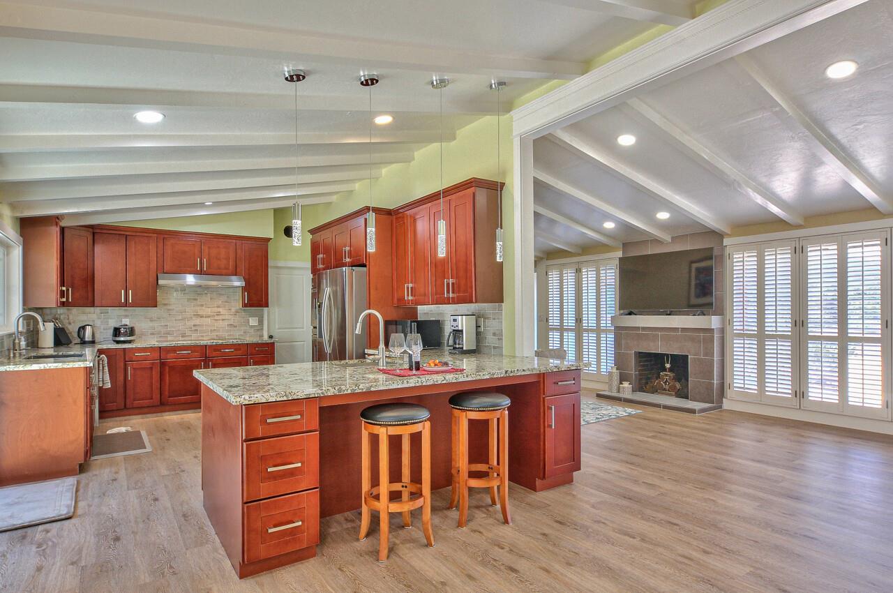 a dining hall with stainless steel appliances granite countertop a stove oven a flat screen tv and a fireplace
