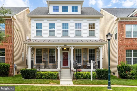a front view of a house with a yard and potted plants