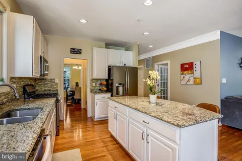 a large kitchen with kitchen island granite countertop a sink stove and refrigerator