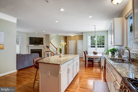 a large kitchen with sink a counter space and stainless steel appliances