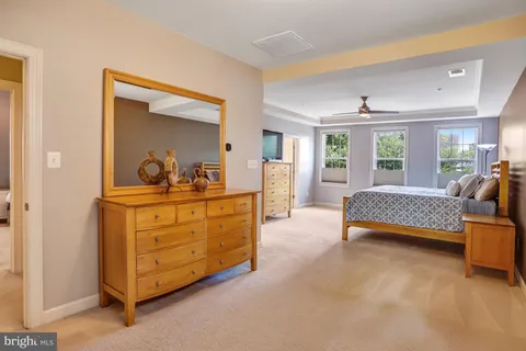 a bedroom with a bed and a flat tv screen on dresser