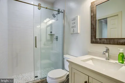 a bathroom with a sink a toilet and shower