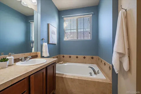 a bathroom with a tub sink and mirror