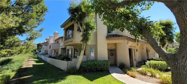 a view of a white house with a yard and plants