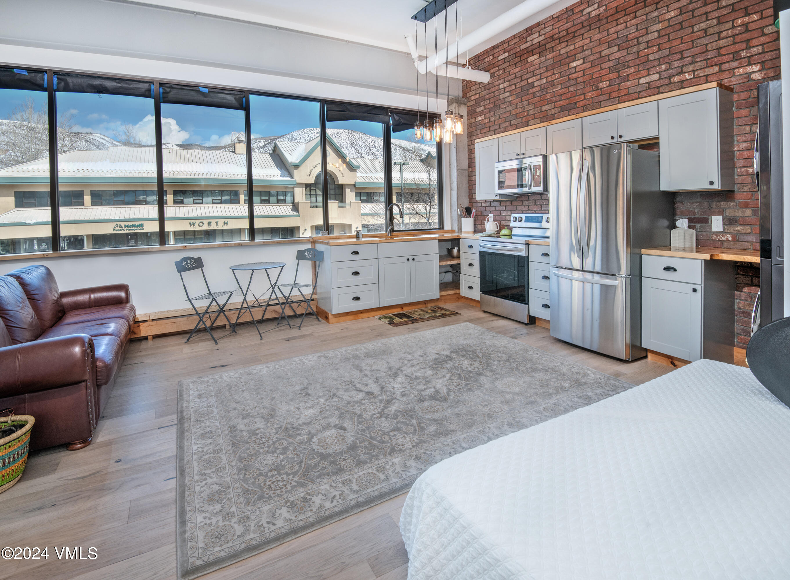 70 Benchmark Road, Unit 201 Avon, CO 81620 - Photo 4 of 32 a kitchen with a refrigerator a sink and white cabinets