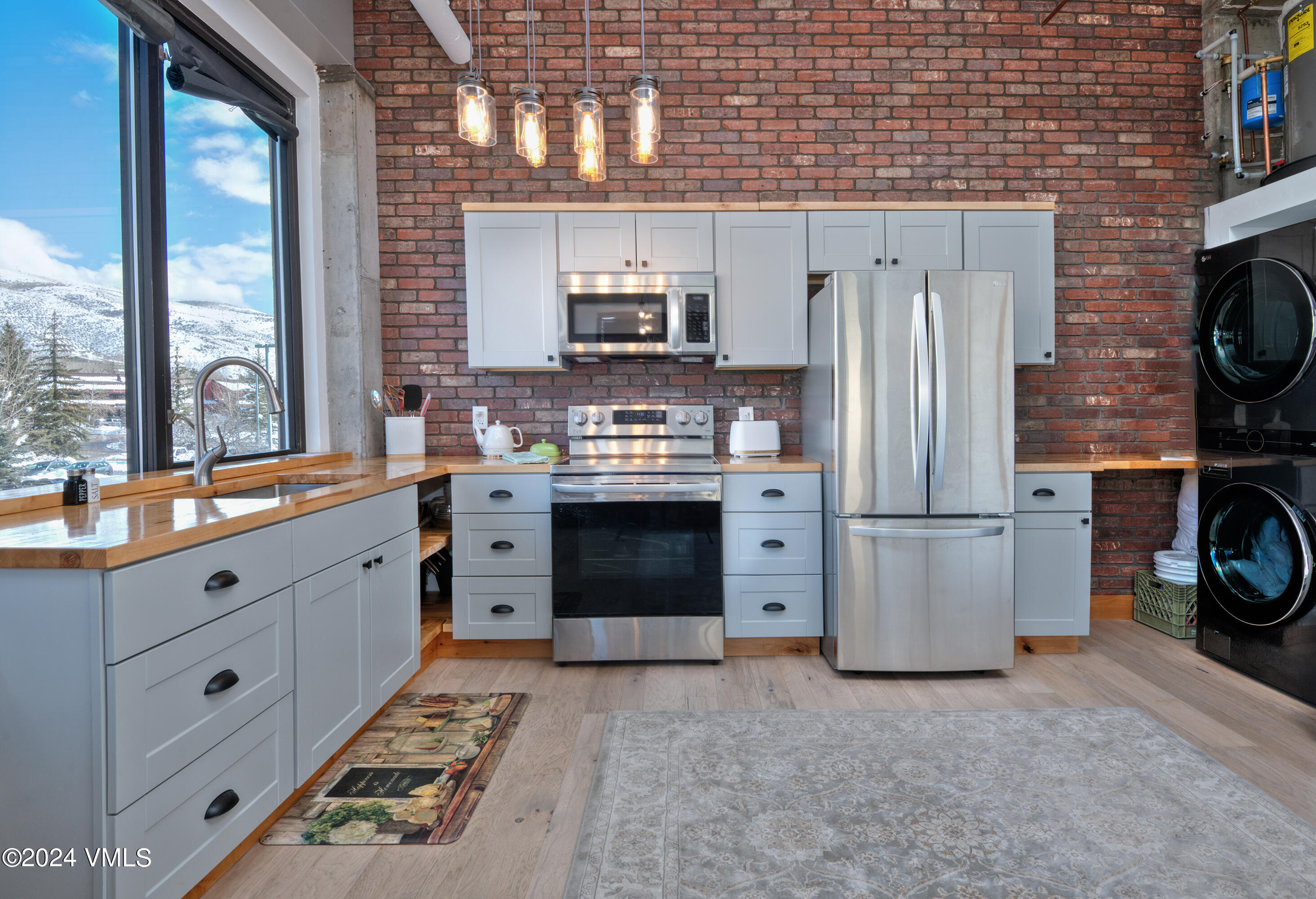 70 Benchmark Road, Unit 201 Avon, CO 81620 - Photo 7 of 32 a kitchen with stainless steel appliances a stove a refrigerator and a cabinets