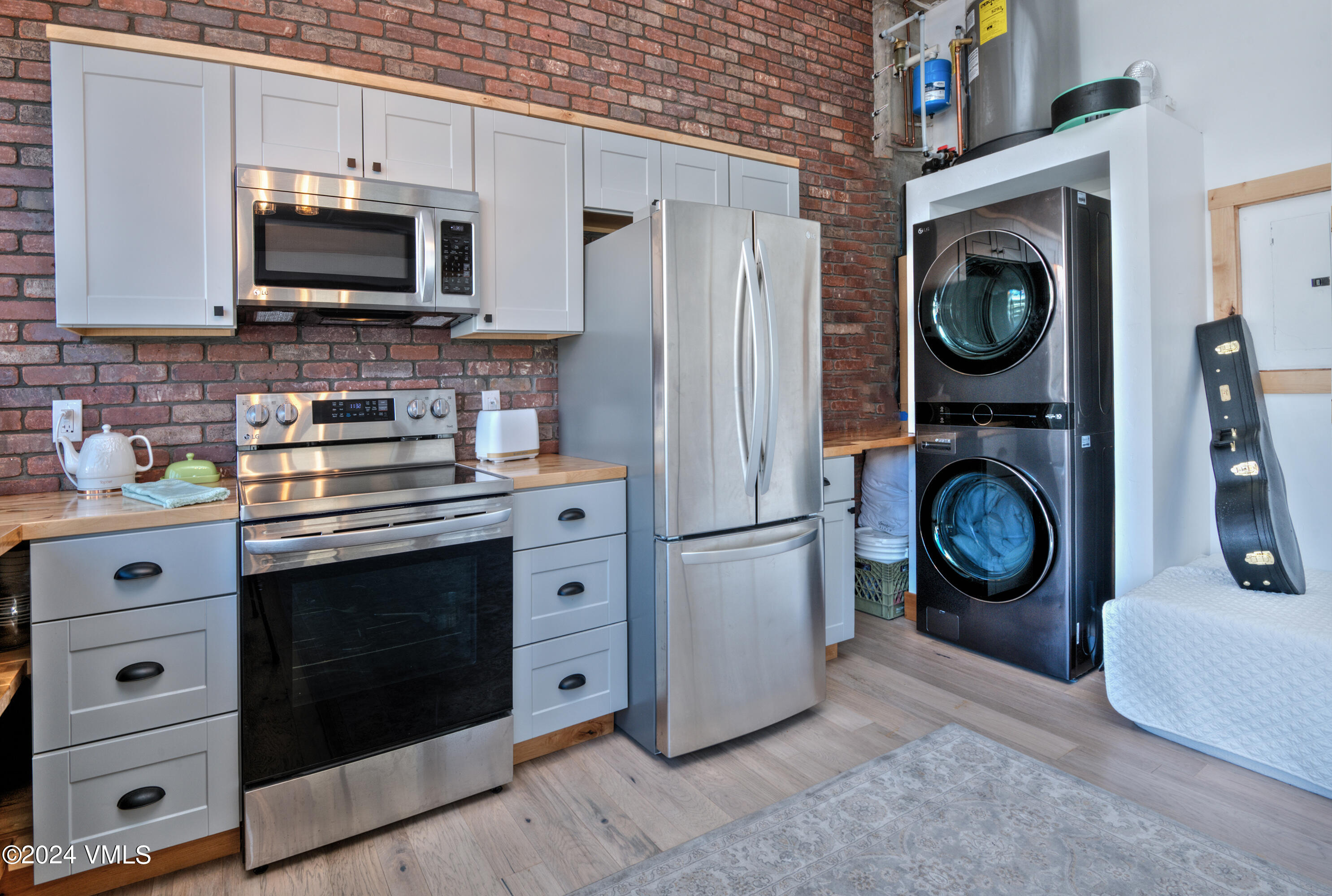 70 Benchmark Road, Unit 201 Avon, CO 81620 - Photo 8 of 32 a kitchen with stainless steel appliances granite countertop a stove a microwave a washer and dryer