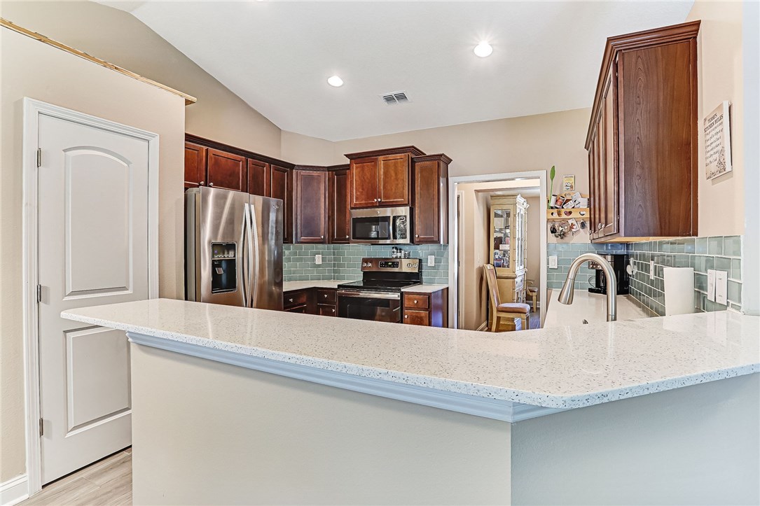 88381 Maybourne Road Yulee, FL 32097 - Photo 11 of 24 a kitchen with stainless steel appliances granite countertop a refrigerator and a sink