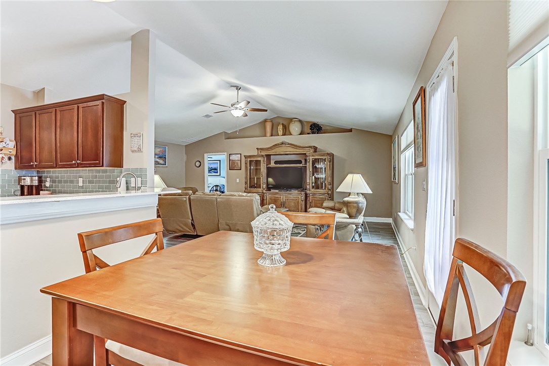 88381 Maybourne Road Yulee, FL 32097 - Photo 13 of 24 a dining hall with granite countertop a stove a sink a dining table and chairs with wooden floor