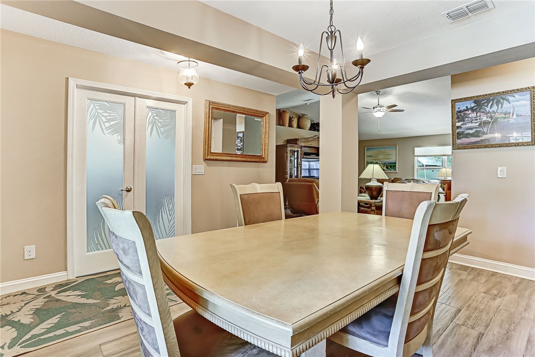 88381 Maybourne Road Yulee, FL 32097 - Photo 18 of 24 a view of a dining room with furniture a chandelier and wooden floor