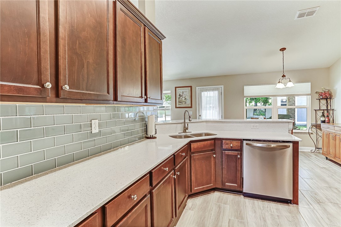 88381 Maybourne Road Yulee, FL 32097 - Photo 7 of 24 a kitchen with kitchen island granite countertop a sink a counter top space and cabinets