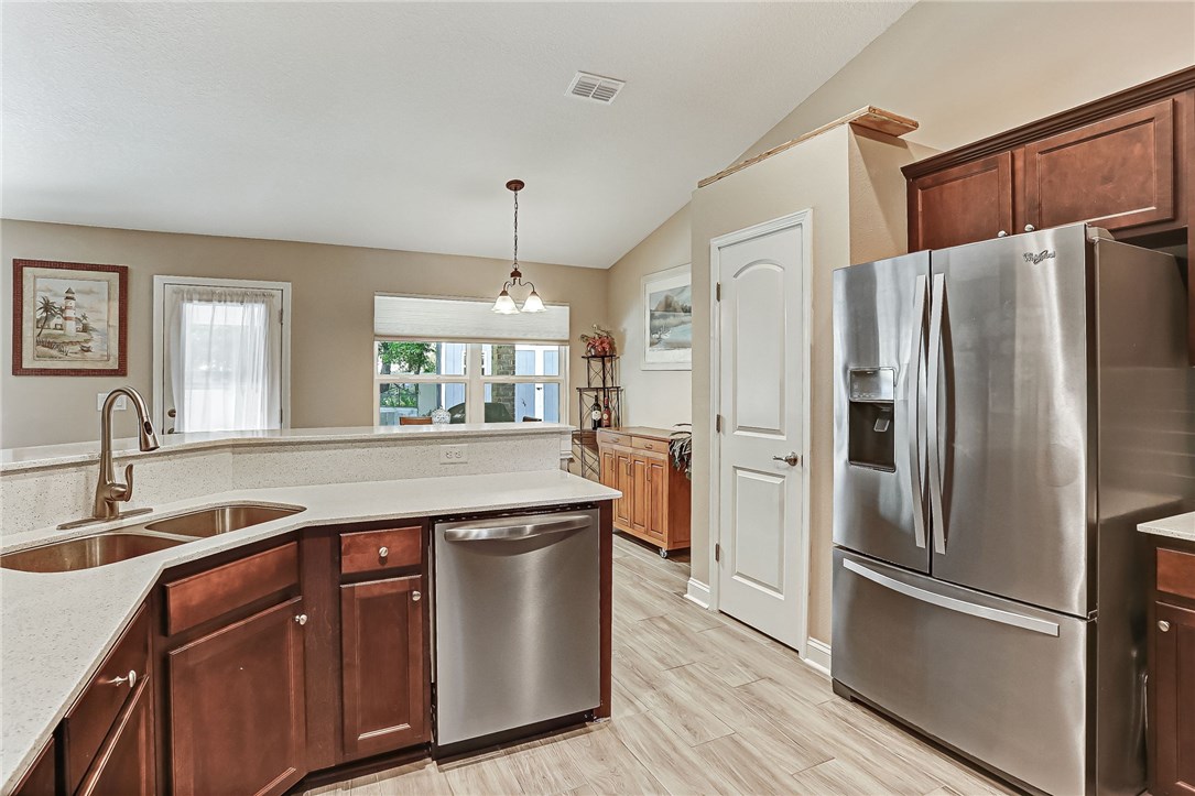 88381 Maybourne Road Yulee, FL 32097 - Photo 8 of 24 a kitchen with stainless steel appliances granite countertop a refrigerator a sink a stove and a refrigerator