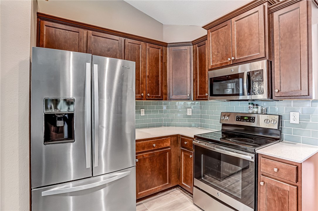 88381 Maybourne Road Yulee, FL 32097 - Photo 9 of 24 a kitchen with granite countertop a refrigerator stove and microwave
