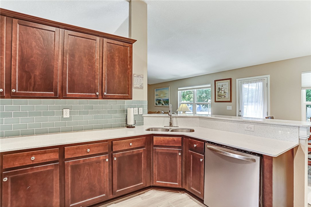 88381 Maybourne Road Yulee, FL 32097 - Photo 10 of 24 a kitchen with stainless steel appliances granite countertop a sink window and cabinets