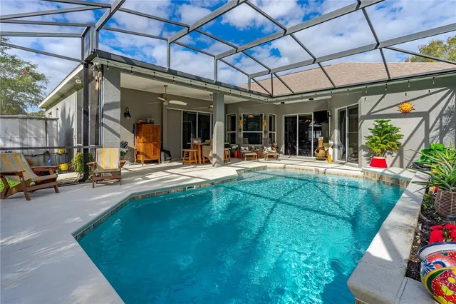 a view of a patio with table and chairs near a barbeque