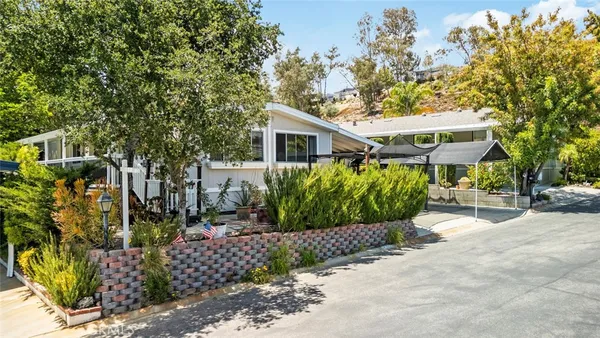 a front view of a house with a yard and potted plants