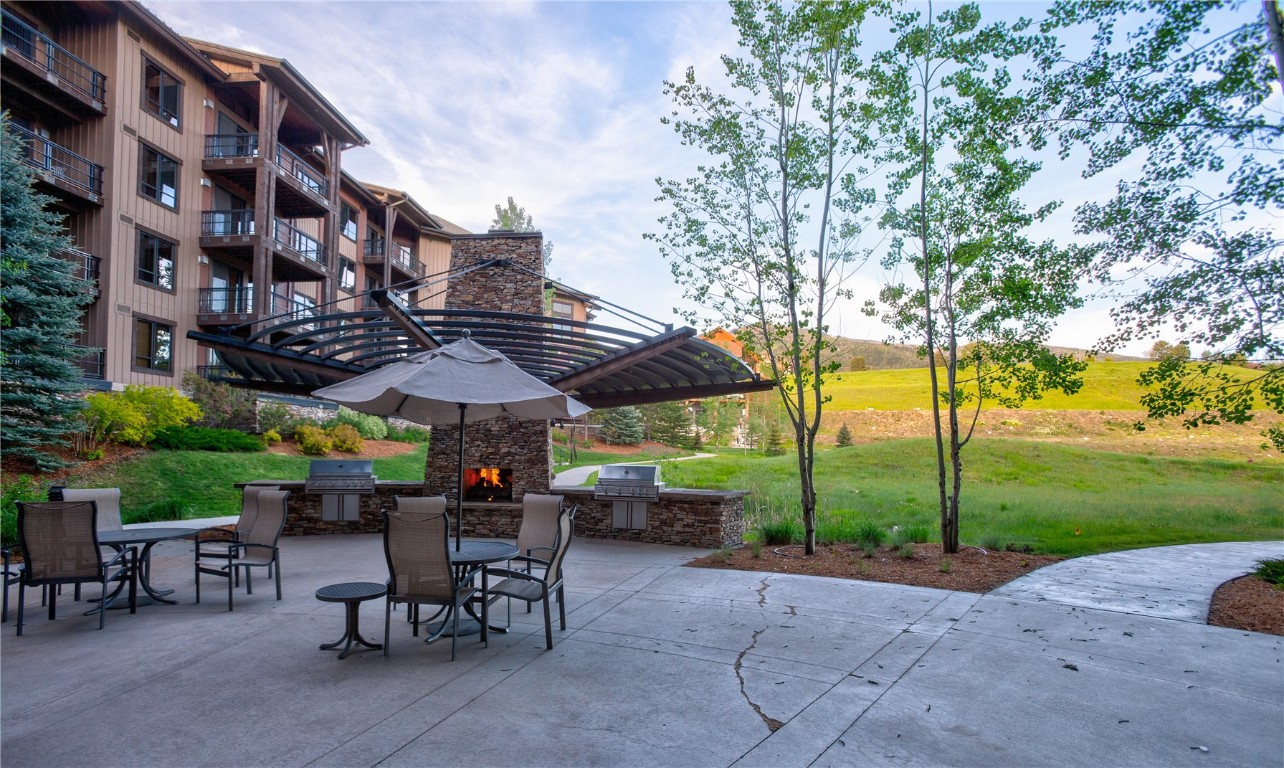 2796 Bronc Buster Loop Steamboat Springs, CO 80487 - Photo 13 of 15 a view of patio with table and chairs under an umbrella with large trees
