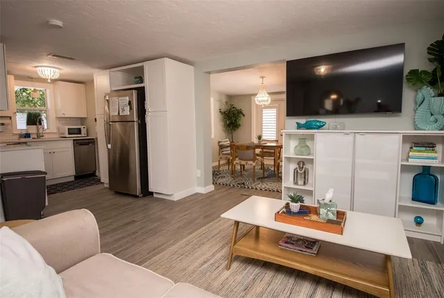 a living room with furniture a flat screen tv and a table