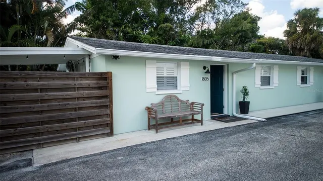 a view of a house with a barbeque and wooden fence