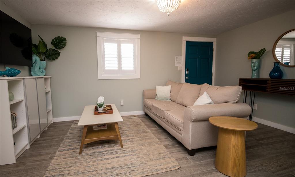 1805 Ivanhoe Street Sarasota, FL 34231 - Photo 21 of 34 a living room with furniture a flat screen tv and a table