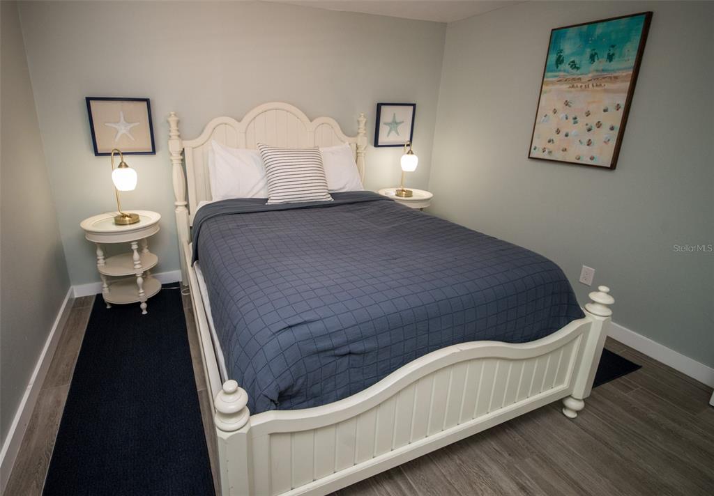 1805 Ivanhoe Street Sarasota, FL 34231 - Photo 27 of 34 a bed sitting in a bedroom and a lamp on dresser with wooden floor