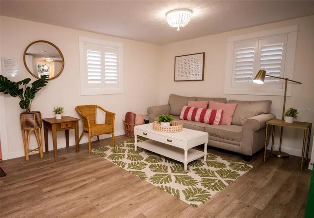 a living room with furniture a wooden floor and a large window