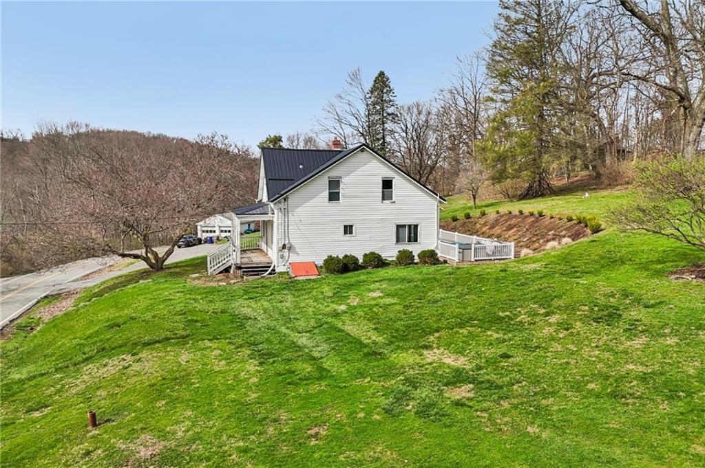 6012 Cunningham Road Gibsonia, PA 15044 - Photo 24 of 26 a view of a white house that has a big yard and large trees