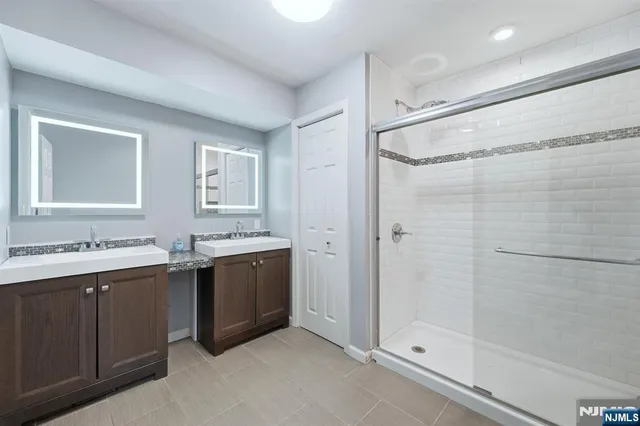 a bathroom with a tub sink shower and mirror