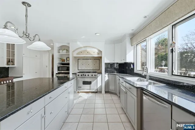 a kitchen with stainless steel appliances a sink stove and cabinets