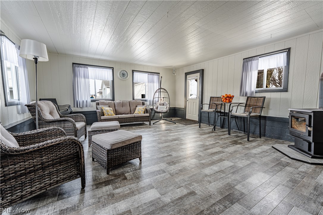 16350 Nauvoo Road Middlefield, OH 44062 - Photo 47 of 50 Living area with a wood stove and wood finished floors