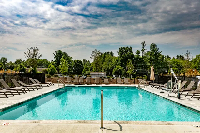 a view of a swimming pool with lawn chairs