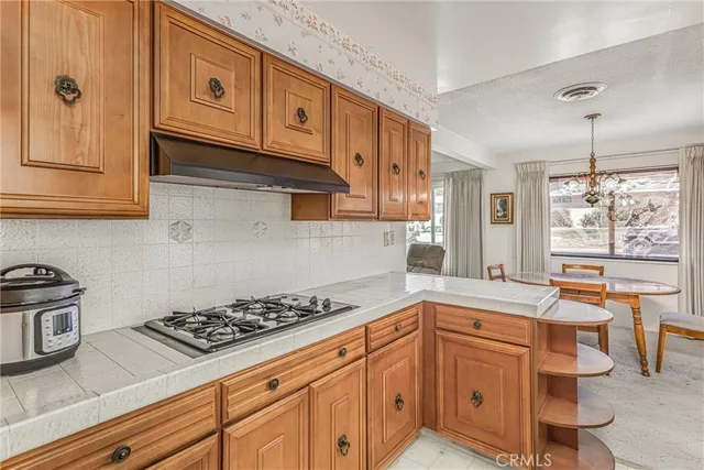 a kitchen with stainless steel appliances a stove a sink cabinets and wooden floor