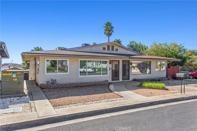 a front view of a house with a garden and yard