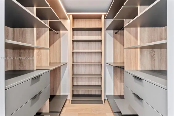 a view of walk in closet with empty racks