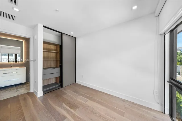 an empty room with closet and a window