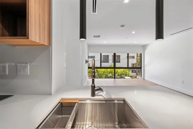 a view of a kitchen with a sink and large window