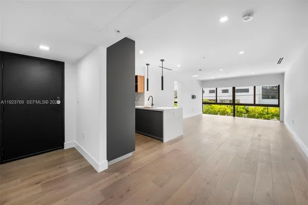 a view of a big room with wooden floor and windows