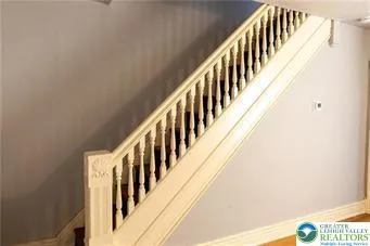 a view of staircase with railing and white walls