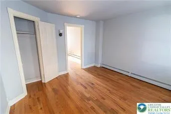 an empty room with wooden floor and closet