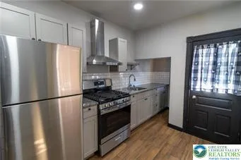 a kitchen with stainless steel appliances a refrigerator sink and cabinets