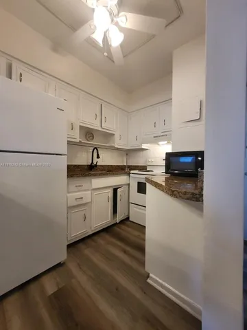 a kitchen with a white cabinets and white appliances
