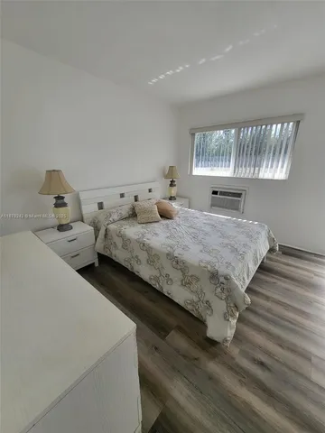 a bedroom with bed and wooden floor