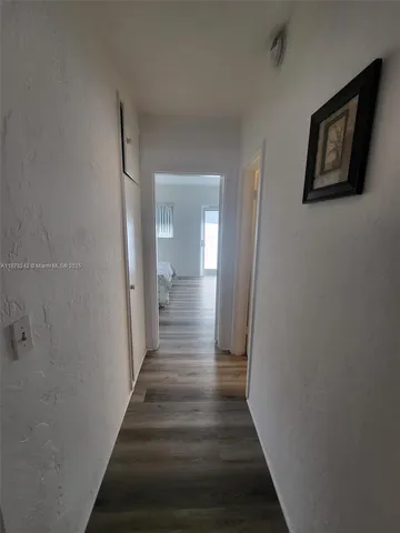a view of a hallway with wooden floor and a hallway