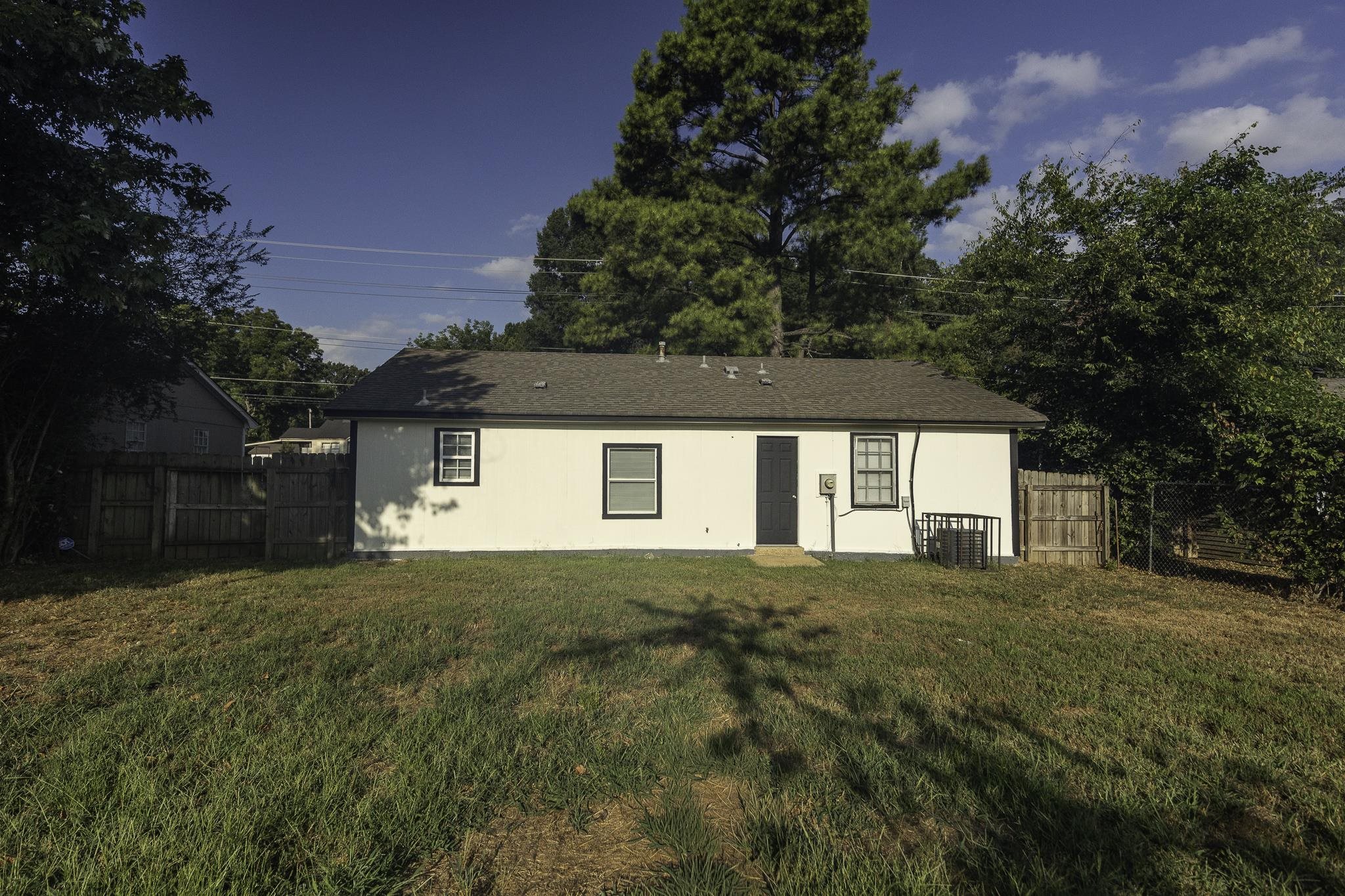4780 Hillbrook Road Memphis, TN 38109 - Photo 7 of 25 White exterior with black trim windows, a dark gray door, and a brown shingle roof