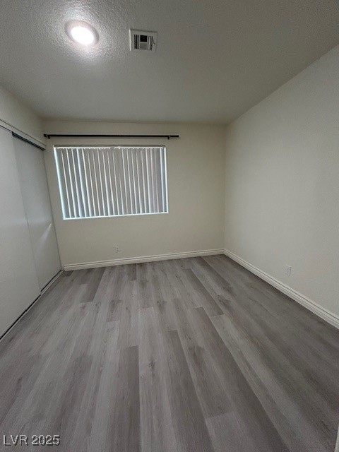 5044 South Rainbow Boulevard, Unit 106 Las Vegas, NV 89118 - Photo 9 of 18 Spare room featuring wood finished floors and a textured ceiling